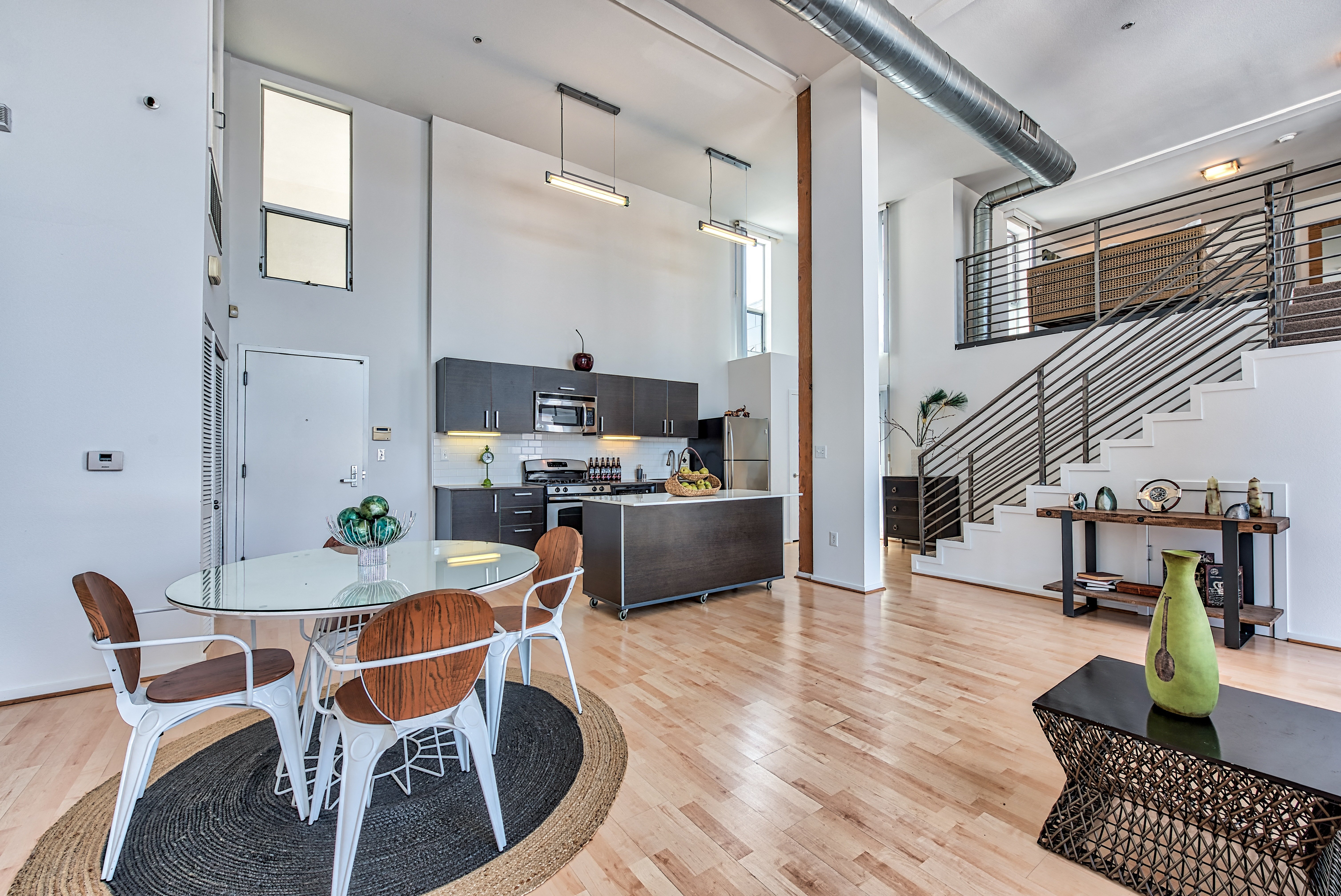 A modern dining room with a glass table and chairs.